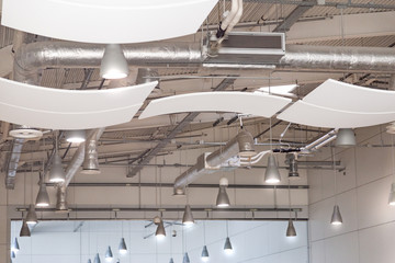 Ceeling installation of lights, air conditioning and security systems with sound and vibration reducing panels in a modern mall or airport