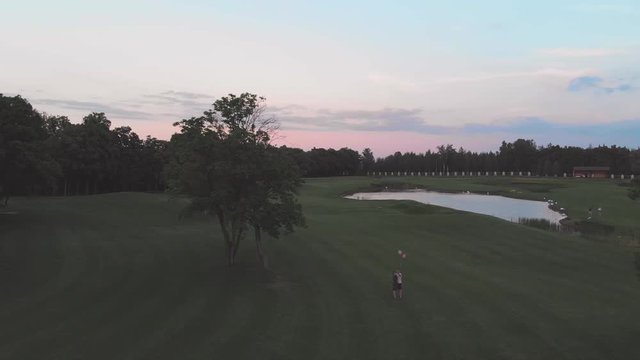 The guy and the girl let go of the inflatable balls in the park, with a quadrocopter