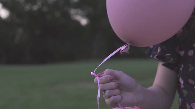 The guy and the girl let go of the inflatable balls in the park