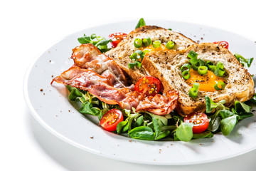 Breakfast - toasted bread with fried egg, bacon and vegetables