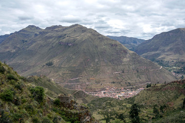 Fototapeta na wymiar Landscape with green Andean Mountains and Inca ruins on the hiking path in Pisac archeological park, Peru