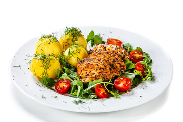 Grilled chicken fillet and vegetables on white plate