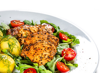 Grilled chicken fillet and vegetables on white plate