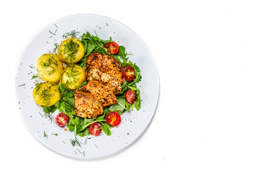 Grilled chicken fillet and vegetables on white plate
