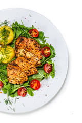 Grilled chicken fillet and vegetables on white plate