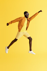 Fototapeta na wymiar Jump. Man jumping, flying like superhero on yellow background
