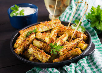 Baked zucchini sticks with cheese and bread crumbs. Vegan food. Vegetarian cuisine.
