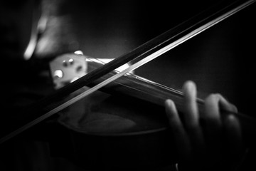 Close-up shot little girl playing violin orchestra instrumental with dark tone and lighting effect...