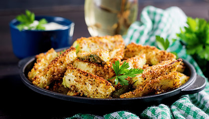Baked zucchini sticks with cheese and bread crumbs. Vegan food. Vegetarian cuisine.