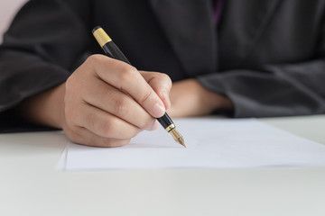 Close up shot hand of business woman using the pen to write on the white paper select focus shallow...