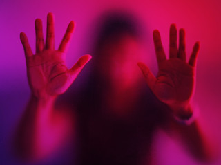 Blurry woman hand behind frosted glass metaphor panic and negative dark emotional