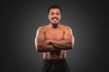 Smiling asian man with muscular upper body isolated on grey background. Fitness, workout and training concept.