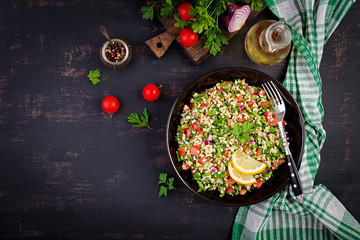 Tabbouleh salad. Traditional middle eastern or arab dish. Levantine vegetarian salad with parsley, mint, bulgur, tomato. Top view