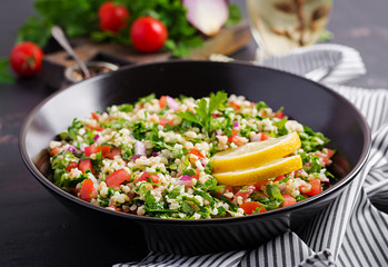 Tabbouleh salad. Traditional middle eastern or arab dish. Levantine vegetarian salad with parsley, mint, bulgur, tomato.