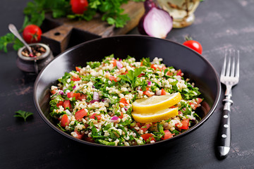 Tabbouleh salad. Traditional middle eastern or arab dish. Levantine vegetarian salad with parsley, mint, bulgur, tomato.