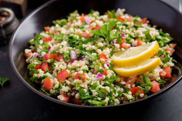 Tabbouleh salad. Traditional middle eastern or arab dish. Levantine vegetarian salad with parsley, mint, bulgur, tomato.