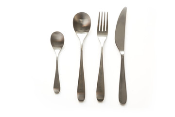 Set of metal elegance and traditional silverware, knife, fork, spoon, tea spoon on white background. Top view.