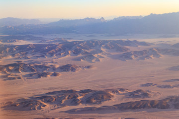Fototapeta na wymiar Aerial view of Arabian desert and mountain range Red Sea Hills near Hurghada, Egypt. View from airplane