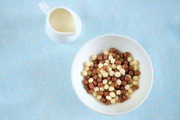 multi-colored chocolate balls for breakfast with milk