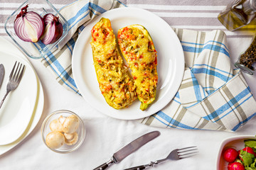 Baked stuffed zucchini boats on top of dining table.