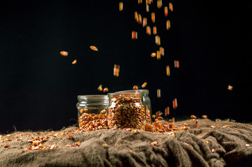 corn grain falls on glass jars