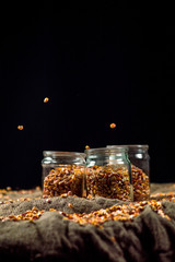 corn grain falls on glass jars