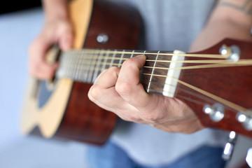 close up acoustic guitar in musician hands, small depth of field