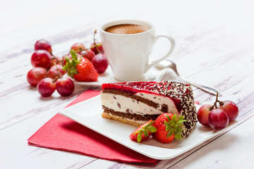 Cake and cup of coffee. Still-life with dessert and fruit and a red napkin on a light background