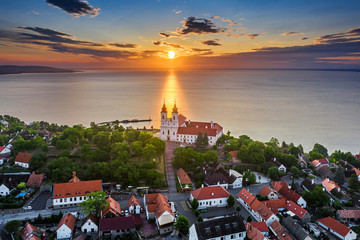 Tihany, Hungary - Aerial skyline view of the famous Benedictine Monastery of Tihany (Tihany Abbey) with beautiful colourful sky and clouds at sunrise over Lake Balaton