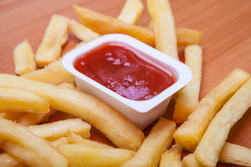 French fries and red sauce isolated on the wood
