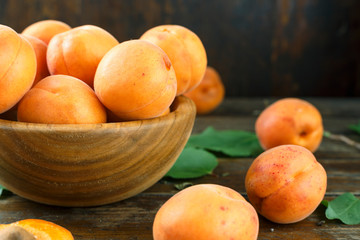 Fototapeta na wymiar Delicious ripe apricots in a wooden bowl