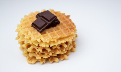 Crispy Belgian waffles with chocolate chips on a white textured surface