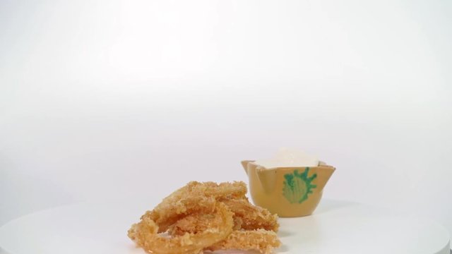 Tapa de Calamares girando, Rings of calamari whit white sauce mayonnaise whit ginger - calamares fritos tipical spanish street food - squid whit white screen rotating in movement, fried recipe 	