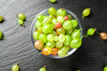 sweet fresh gooseberry berry on dark stone background.
