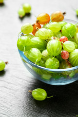 sweet fresh gooseberry berry on dark stone background.