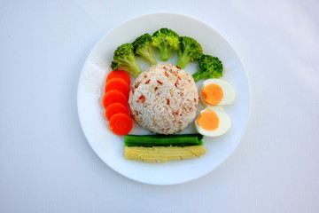 Clean food have brown rice,milk,apple broccoli,carrot,Lentils,Baby corn,and egg in white disc on white background, healthy or vegetarian food concept Top view. 
