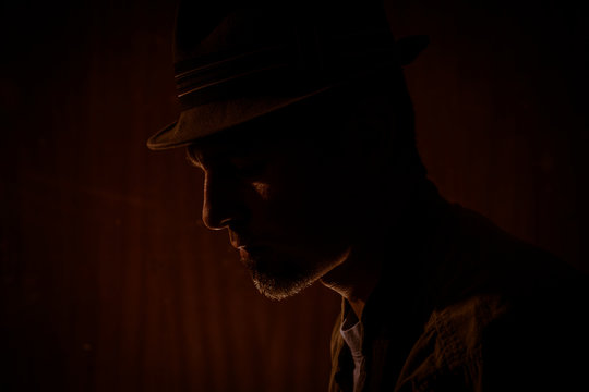 low key portrait of man with borsalino type hat