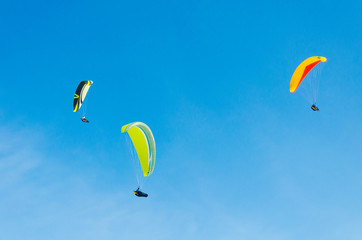 Paragliding in the sky. three paraglider fly over the mountain valley. Competitions with...