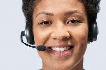 Portrait Of Businesswoman Wearing Telephone Headset In Customer Services Department