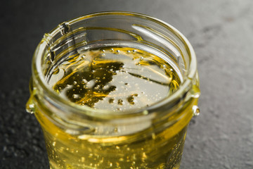 Glass jar with light sweet flower honey. Closeup view. Macro. Selective focus