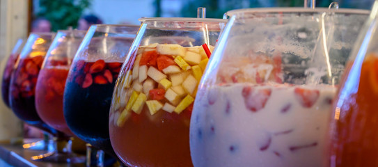 Glasses with punch of various colorful and ice cold fruits.