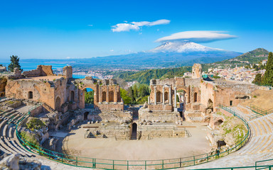 Ancient Greek theatre in Taormina on background of Etna Volcano, Italy