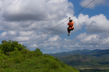 Woman riding in zip line in the Valley of the Sugar Mills in Trinidad Cuba