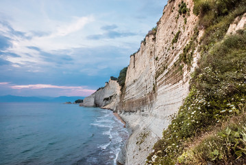 Logas Beach and rocky cliff in Peroulades, Corfu Island, Greece.