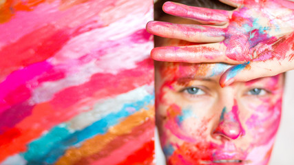 Artist woman concept. Paint on face of young woman artist