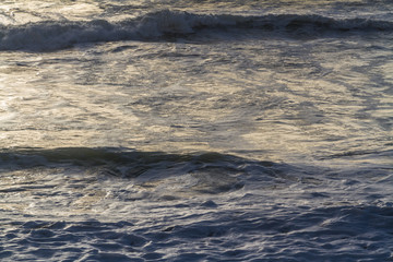 waves on stormy day with sunlight.