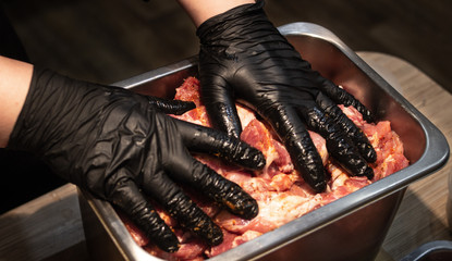 Fototapeta na wymiar Black gloves and raw meat
