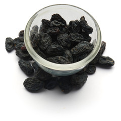 dark raisins isolated in a glass plate