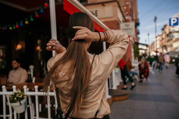 Fototapeta premium Beautiful girl with long hair walks around the city