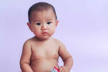 portrait of asian baby girl sitting on white background